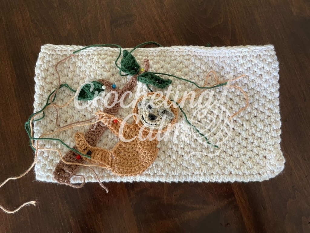 Sloth Zippered Crochet Bag - a work in progress showing the applique pinned to the bag before being sewn on.