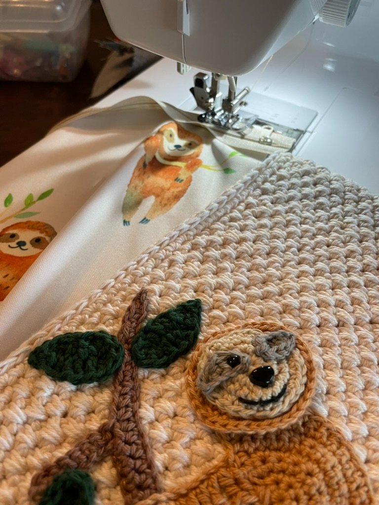 Shows the zipper being attached to sloth fabric to ready it for lining the Sloth Zippered crochet bag
