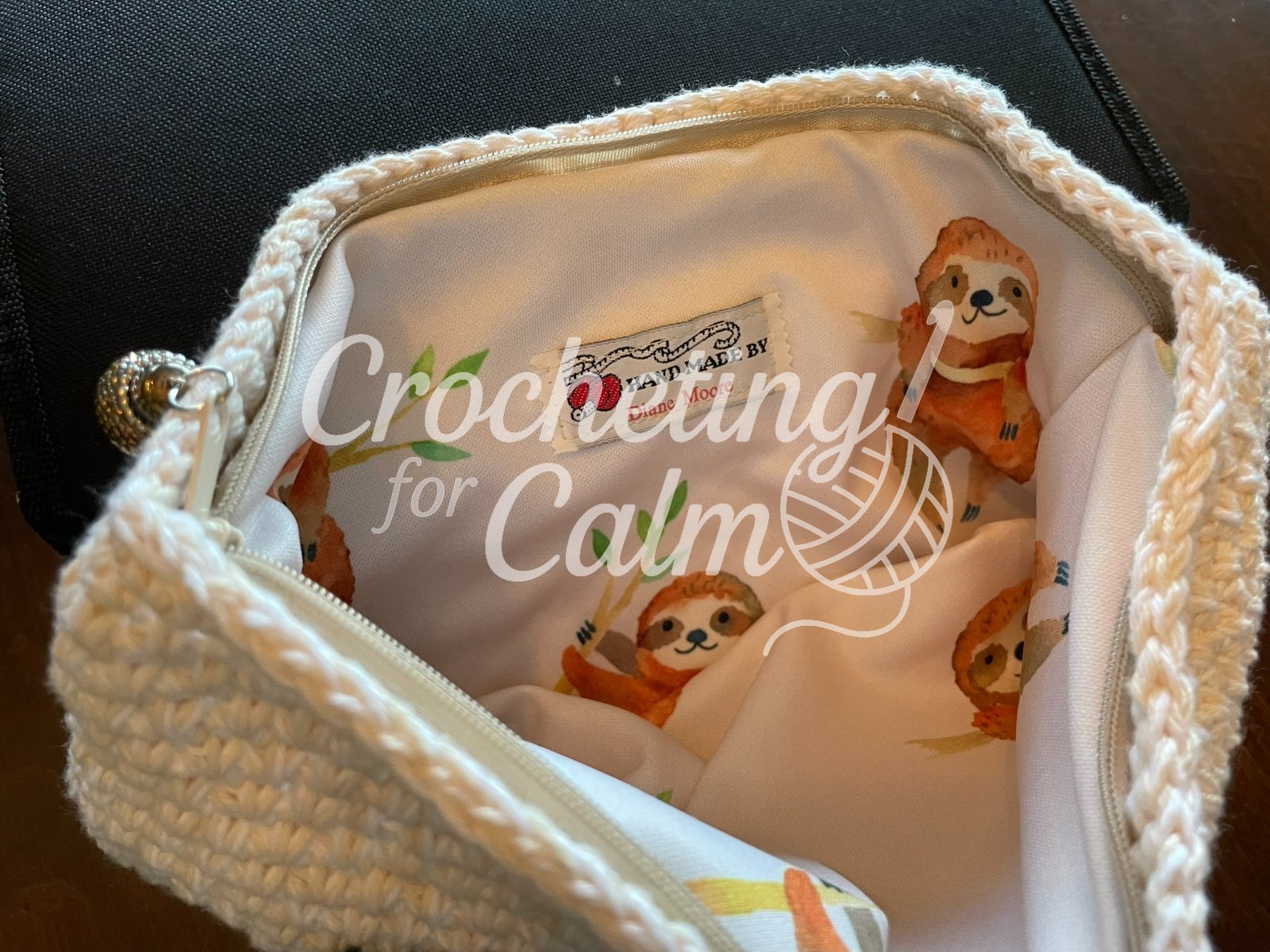 Shows the inside of the Sloth Zippered Crochet Bag featuring a handmade with love tag inside.