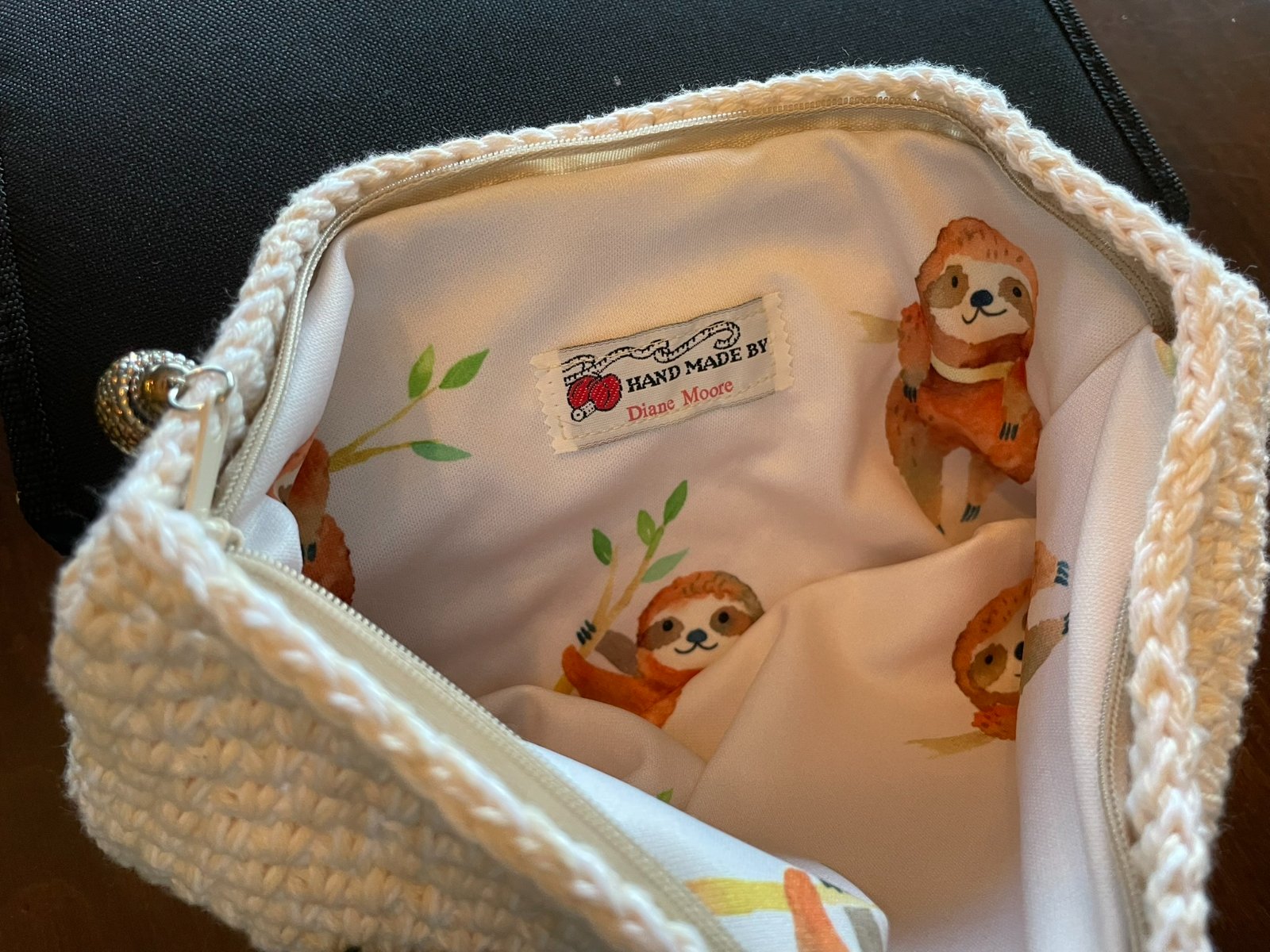 Shows the inside of the Sloth Zippered Crochet Bag featuring a handmade with love tag inside.