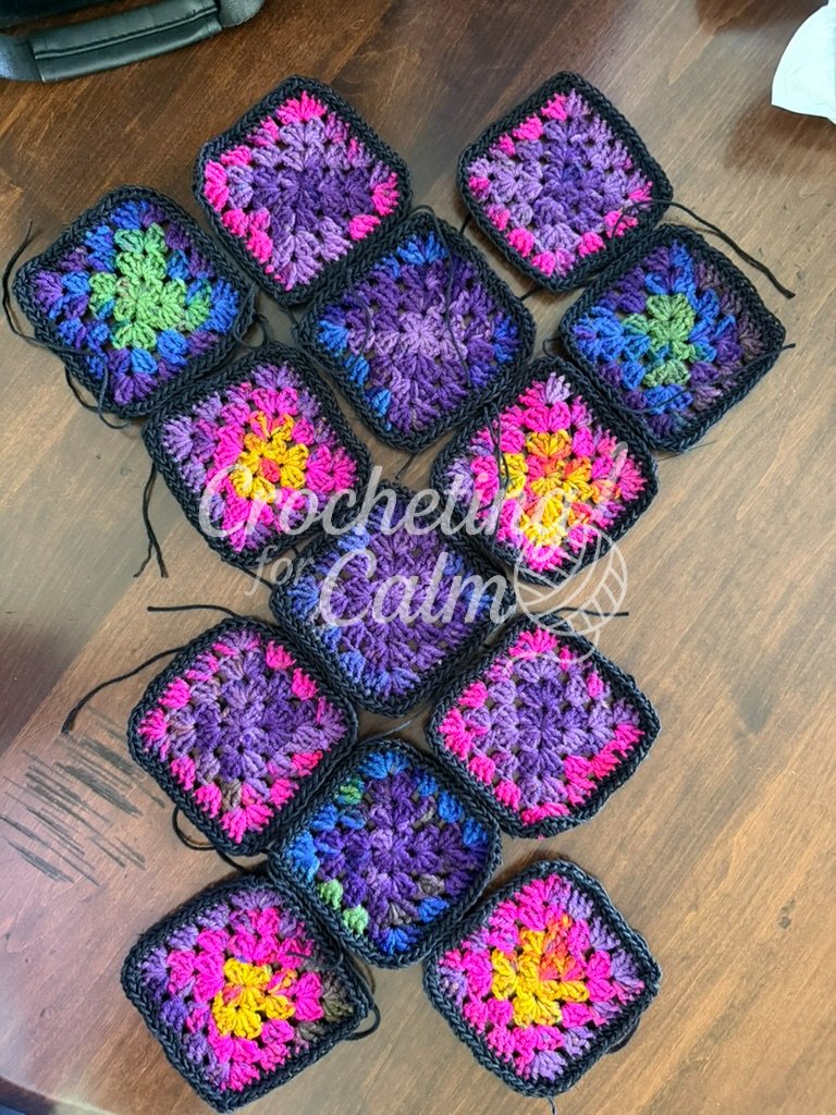 Close-up flat lay of colorful granny squares before they are joined together to prepare to create a 13 square tote.