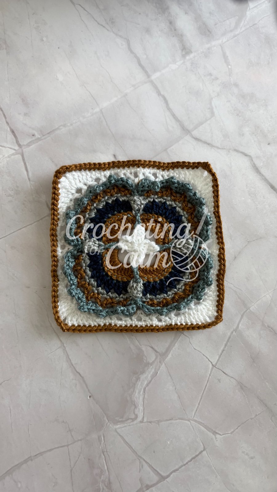 Lilith Granny Square made with dusty teal, navy, white, dark grey and gold yarn.